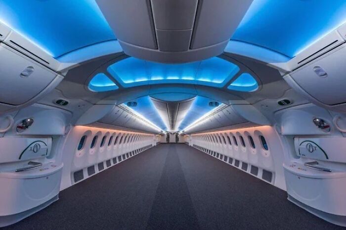 Interior view of an empty airplane cabin showing alternate angles of iconic places with futuristic blue lighting.