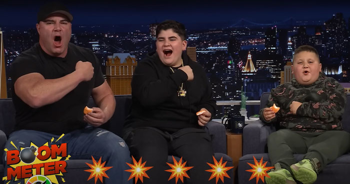 Three men on a late-night talk show set reacting excitedly, related to the Rizzler and internet buzz.