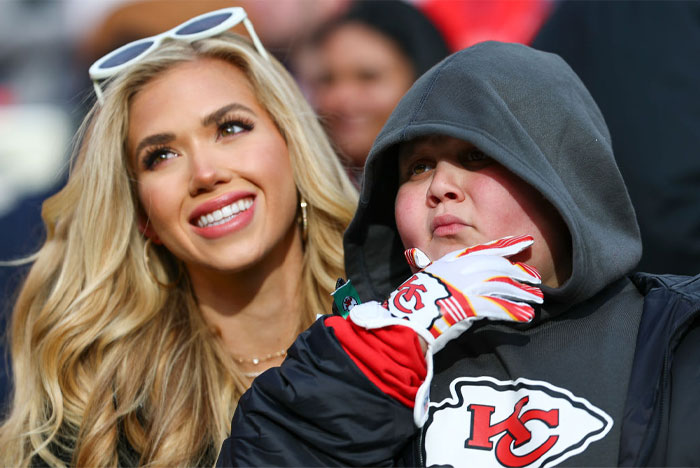 The Rizzler wearing Kansas City Chiefs gear next to a smiling blonde woman, capturing the Rizzler moment.