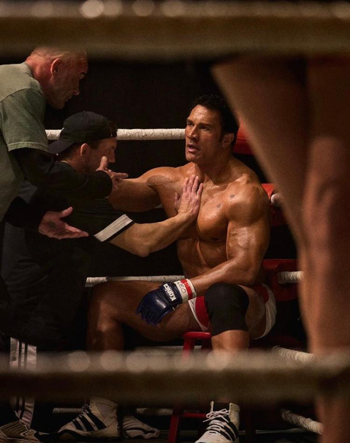 Muscular man in boxing ring surrounded by trainers, sparking racial confusion debate about Dwayne Johnson's film role.