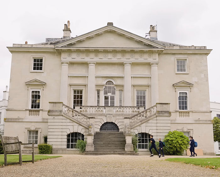 Historic building exterior of Royal Ballet School with students walking in front.