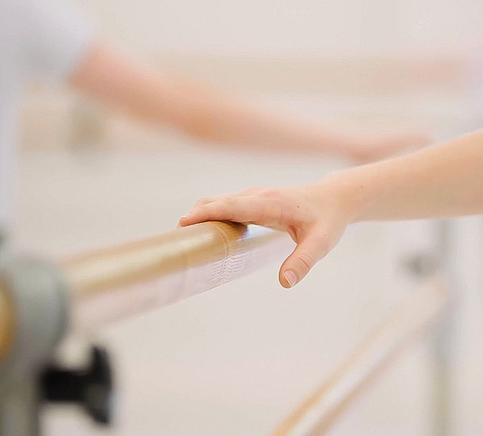 Hand holding a ballet barre, representing the Royal Ballet School's inclusion of plus-size dancers.