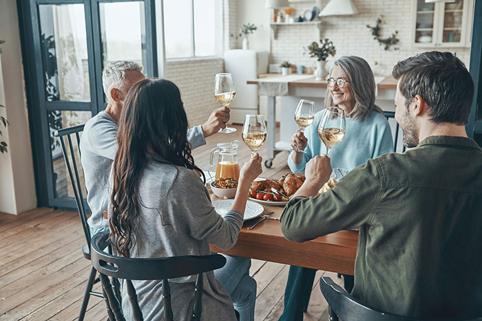 People enjoying a European meal with wine at a cozy dining table.