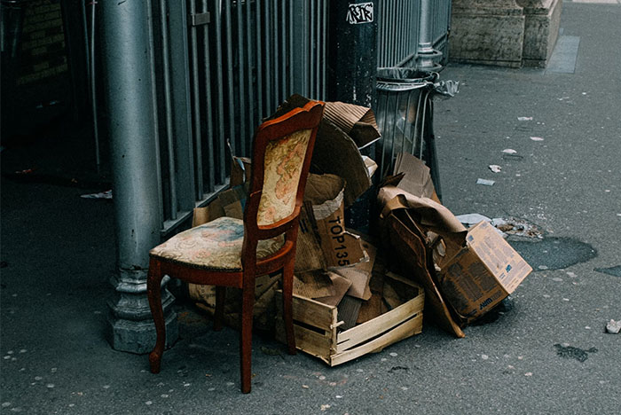 Old chair and boxes by the street, illustrating money-saving tips revived from the Great Recession era.