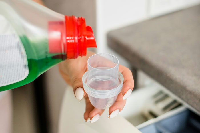 Pouring laundry detergent as a money-saving tip from the Great Recession.