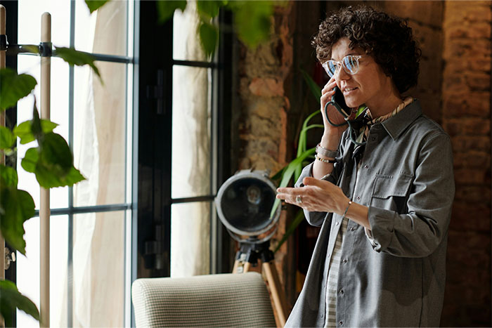 Person using a phone in a stylish home office, demonstrating money-saving tips from the Great Recession.