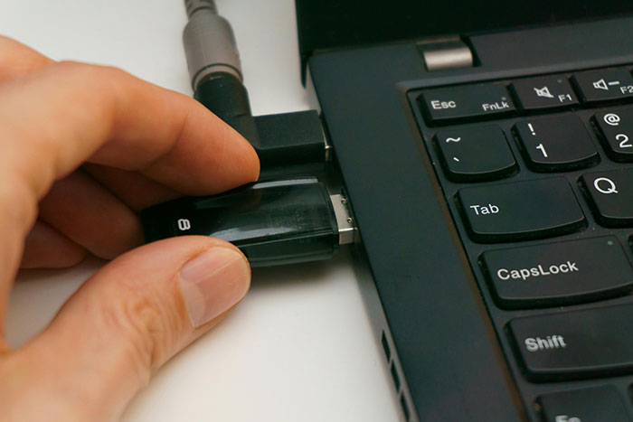 Inserting a USB drive into a laptop for data backup to enhance safety and security.