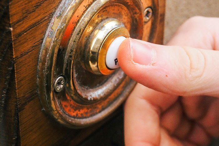 Pressing a doorbell, often overlooked when cleaning before hosting guests.