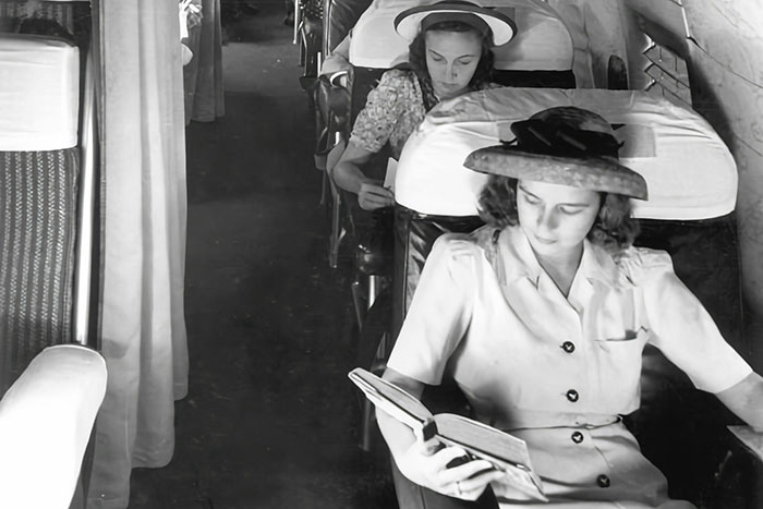Women reading in vintage airplane seats, illustrating how normal flying once was.