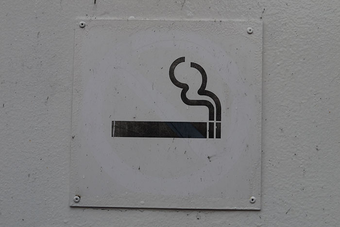 Smoking symbol on a white wall, illustrating a once-normal activity.