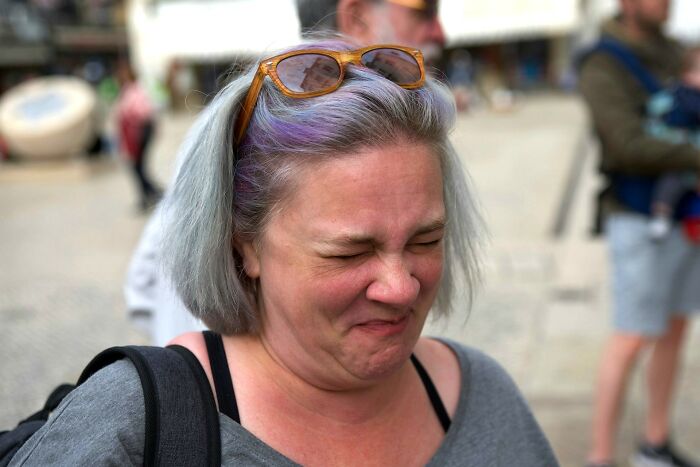 A woman reacting with a disgusted expression outdoors, embodying the most disgusting things witnessed theme.