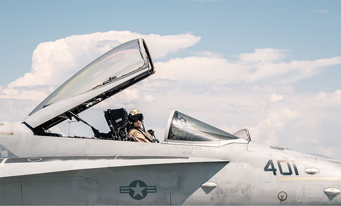 Pilot in a jet cockpit under a blue sky, showcasing military aviation fun facts.