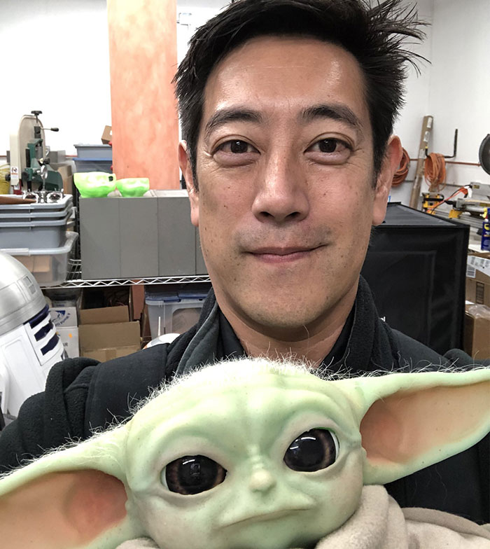 Man holding a Yoda figure in a workshop setting, related to fun facts.