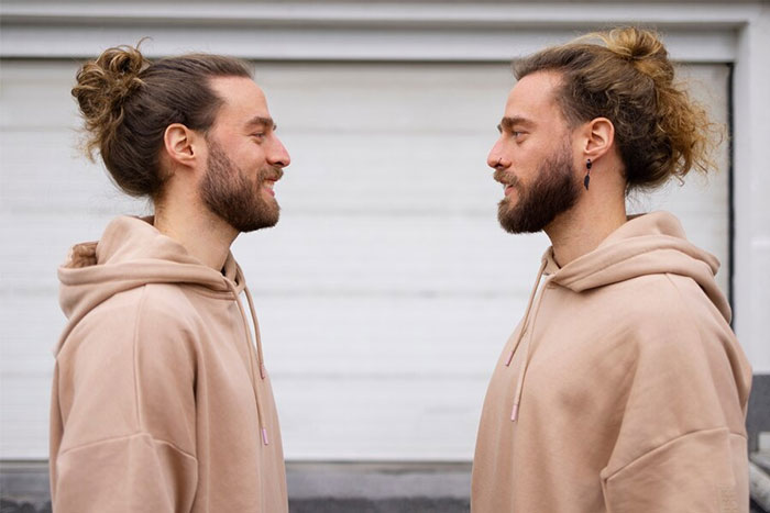 Two men in similar beige hoodies facing each other, highlighting fun facts from learning experiences.