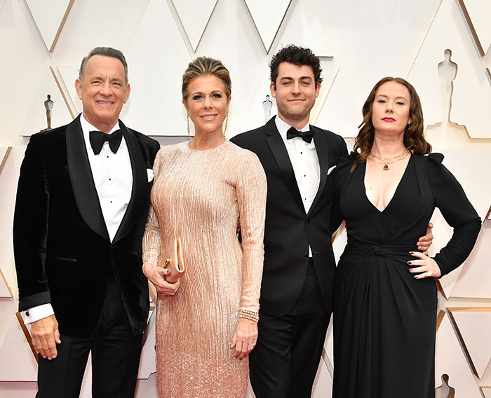 Four people dressed formally at an event, highlighting childhood confusion and deprivation themes.