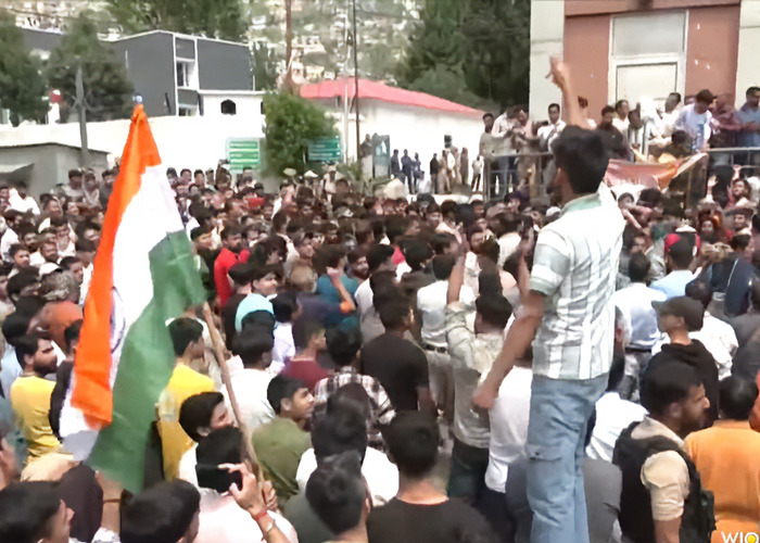 Crowd gathered in protest following horrifying viral video of tourist smiling while zip-lining during mass tragedy.