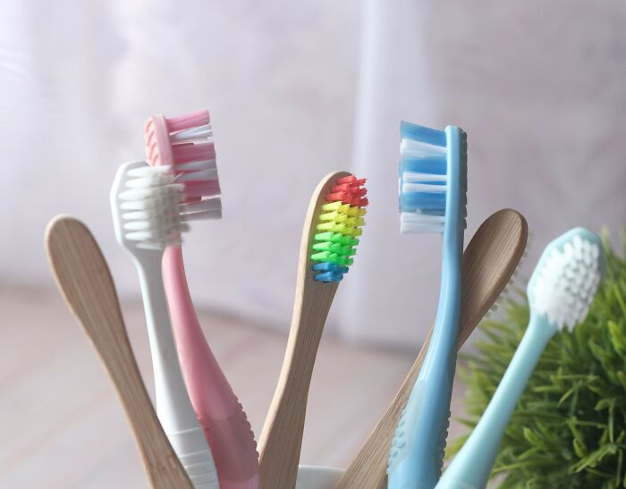 Colorful toothbrushes standing close together, symbolizing relationship arguments that feel like sitcom material.