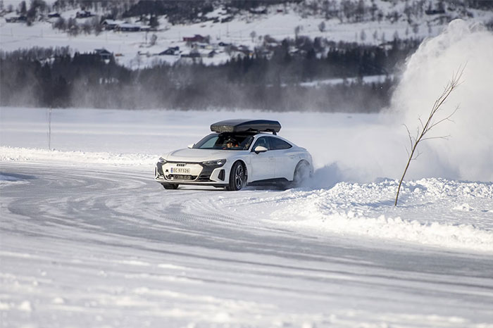 Car driving on snow-covered road, showcasing life-saving winter driving tips.