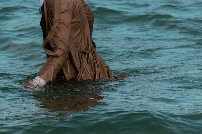 Person in water wearing a brown coat, showcasing a life-saving fact scenario.