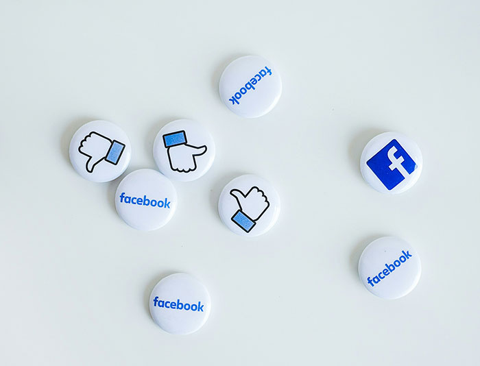 White buttons with Facebook logo and like, thumbs up and thumbs down icons representing moments in history importance.