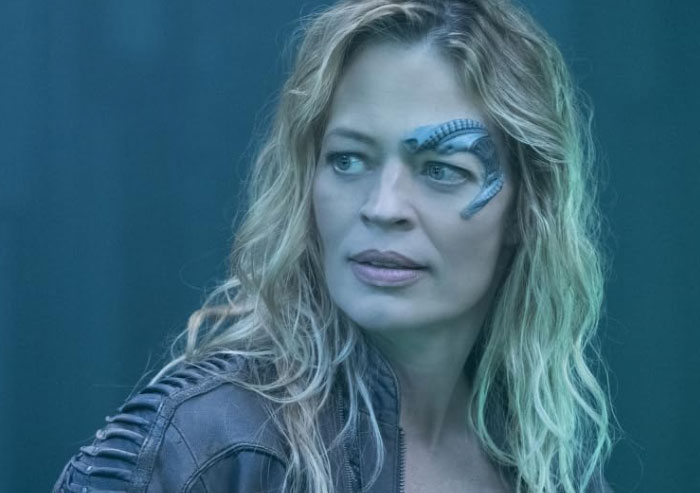 Woman with alien-style facial implant and leather jacket looking to the side, representing moments in history people think are overlooked.