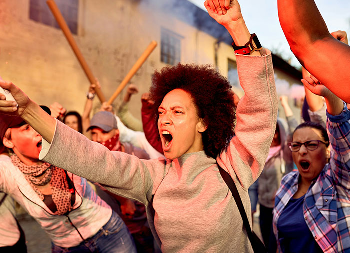 Protesters raising fists and shouting passionately during a historic moment of social unrest and change.