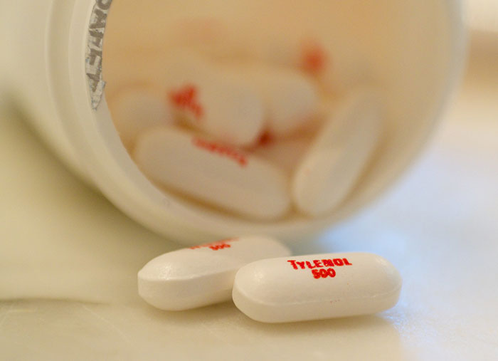 Close-up of Tylenol pills spilled from a bottle, representing a significant moment in history many people overlook.