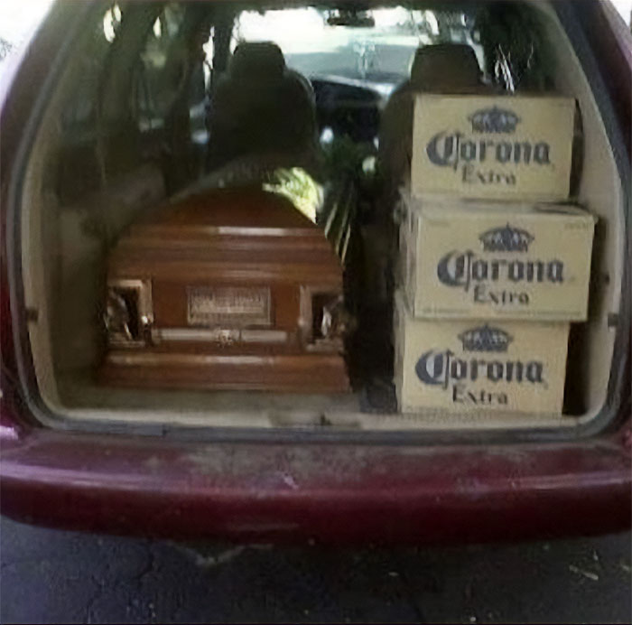 Cursed image of a car trunk containing a casket and Corona beer boxes.