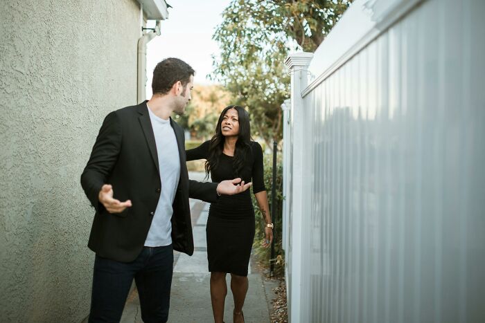 Man and woman arguing in narrow alleyway showing intense emotions reflecting exes actions that still make blood boil.