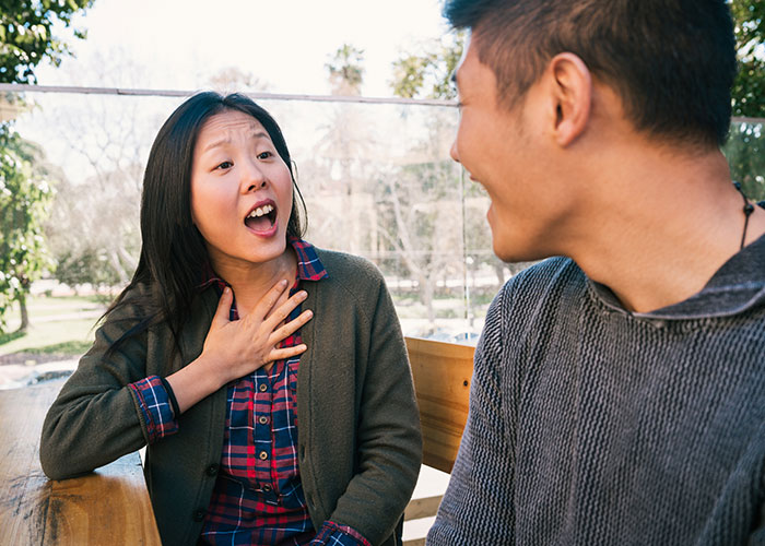A couple engaged in a lively discussion outdoors, illustrating unexpected marriage hacks.