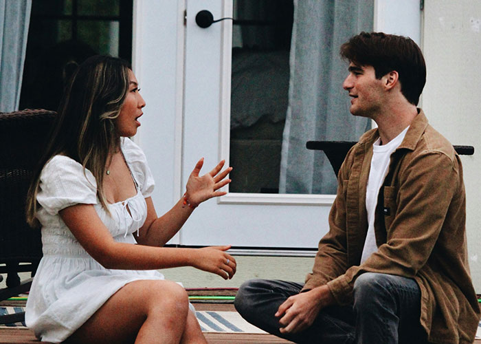 Woman engaging in lively conversation with a man, illustrating ways to decenter men.