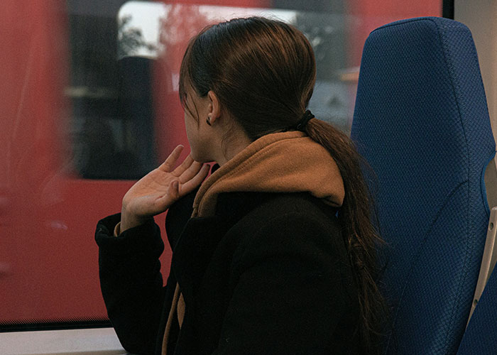 Woman on train gazing out window, embodying ways to decenter men in her life.