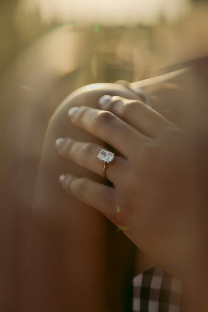 A close-up of a diamond ring on a hand, symbolizing the allure of expensive weddings.