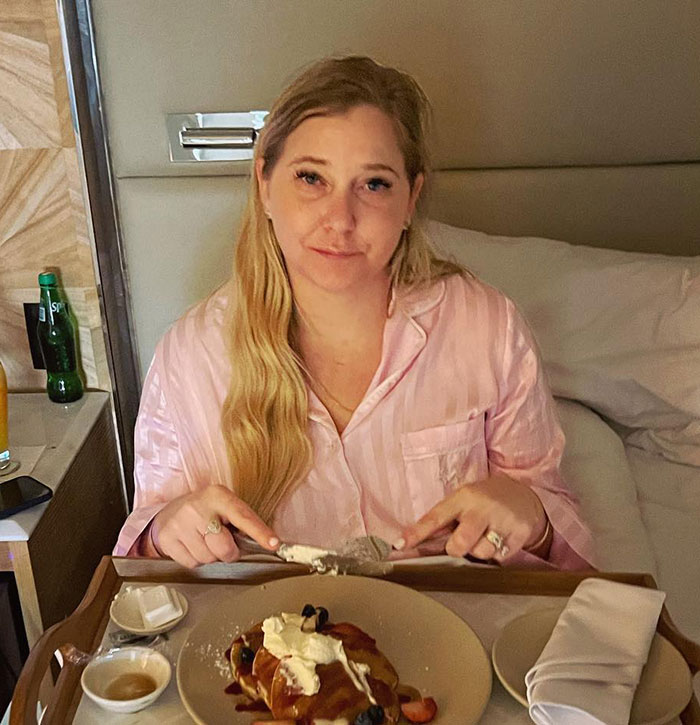 Virginia Giuffre in pink pajamas having breakfast in bed with a lawyer casting doubt on her death claim.