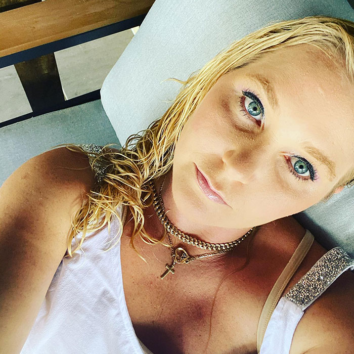 Close-up of a woman with blue eyes and wet blonde hair lying down, related to Virginia Giuffre lawyer claim doubt.