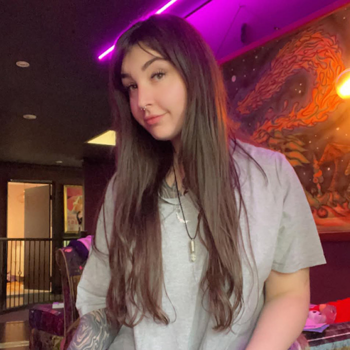 Woman in a casual room setting, relevant to waxing charges based on pubic area size. Woman in a casual room setting, relevant to waxing charges based on pubic area size.