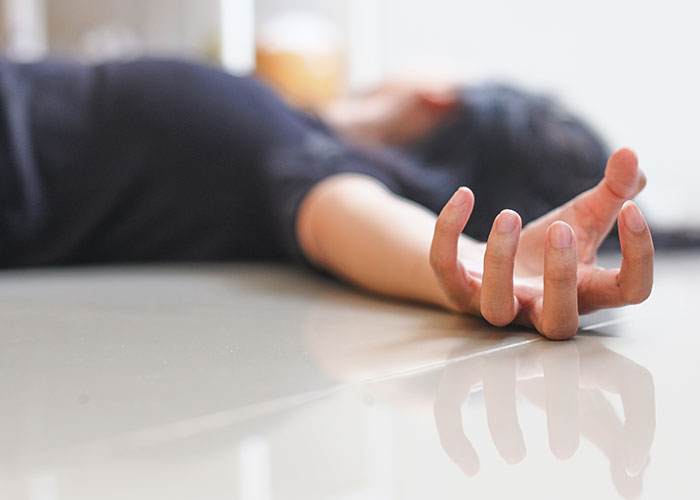 Una persona tumbada en el suelo con la mano extendida, reflejando una experiencia salvaje.