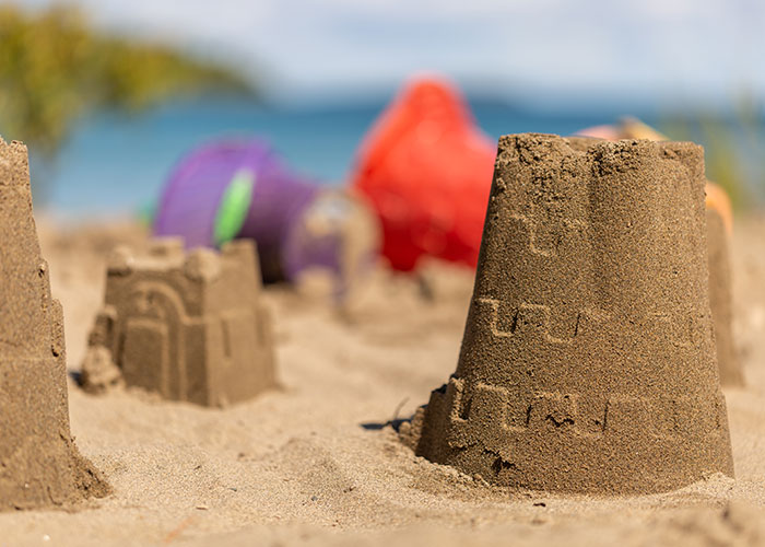 Castillos de arena en la playa, un día soleado ideal para experiencias salvajes y divertidas al aire libre.