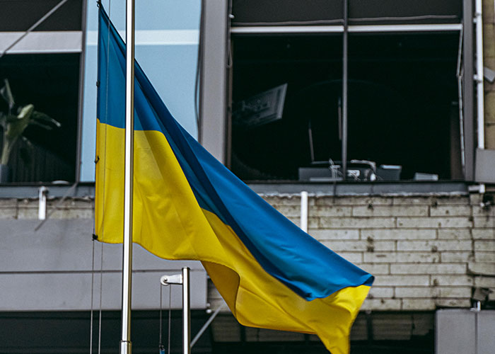 Bandera ondeando frente a un edificio, simbolizando experiencias salvajes que indican irse de allí.