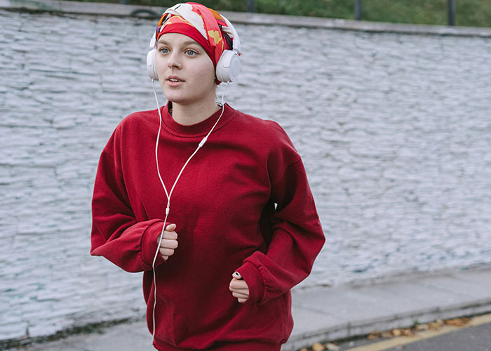 Woman jogging with headphones, trusting intuition on a morning run.