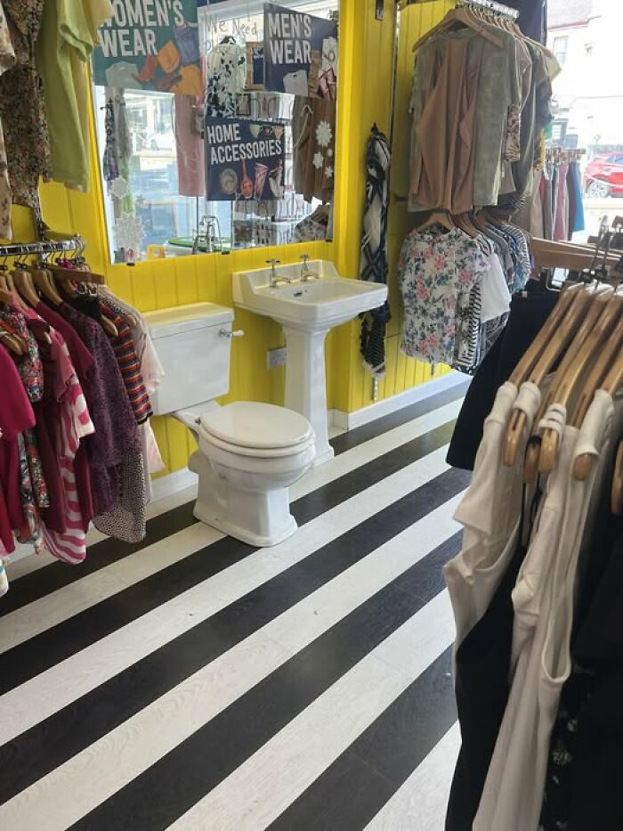 Secondhand shop with clothes, a toilet, and a sink, creating a bizarre treasure find in a retail setting.