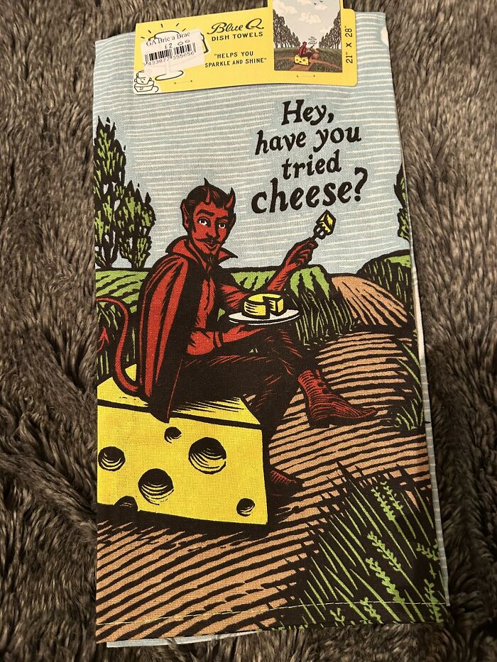 Dish towel with a cartoon devil sitting on cheese, found in a secondhand shop.