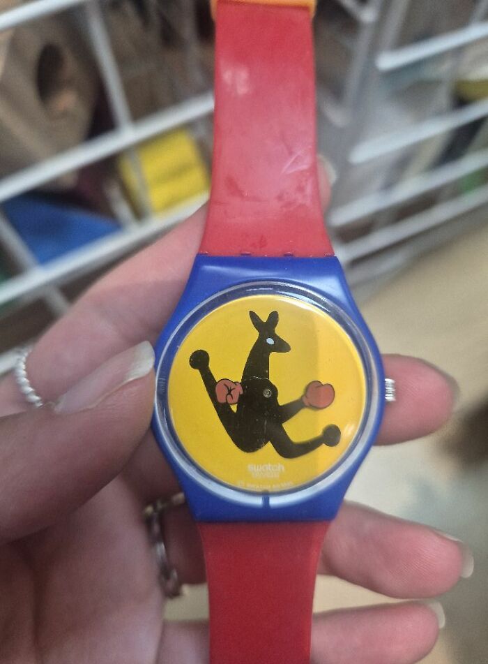 Colorful watch with a kangaroo design, a bizarre treasure from a secondhand shop, featuring a red strap and yellow face.