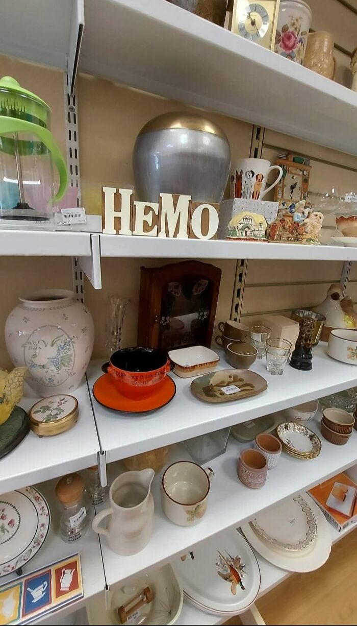 Secondhand shop shelf displaying eclectic treasures, including cups, plates, and decorative items.