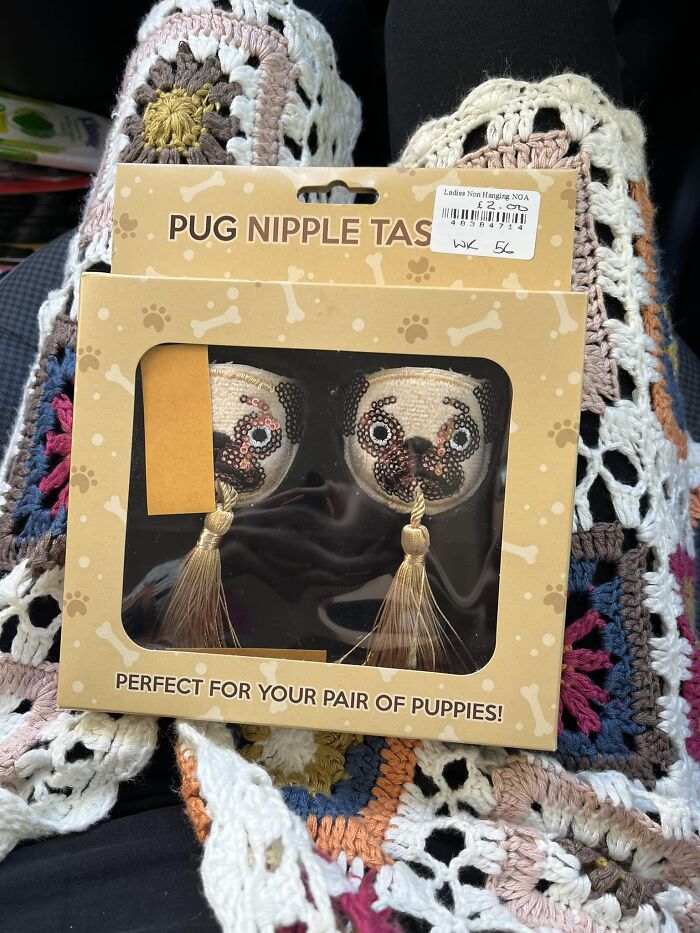 Bizarre treasure from secondhand shop: pug-themed n****e tassels in decorative packaging on a crocheted blanket.
