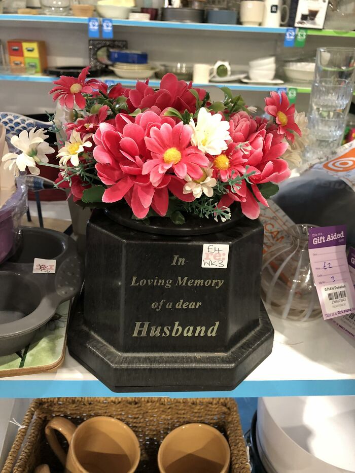 Memorial flower pot with message "In Loving Memory of a dear Husband" on a shelf in a secondhand shop.