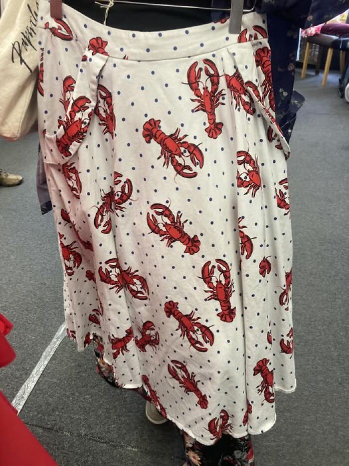 White skirt with red lobster print, spotted in a secondhand shop, showcasing bizarre treasures.