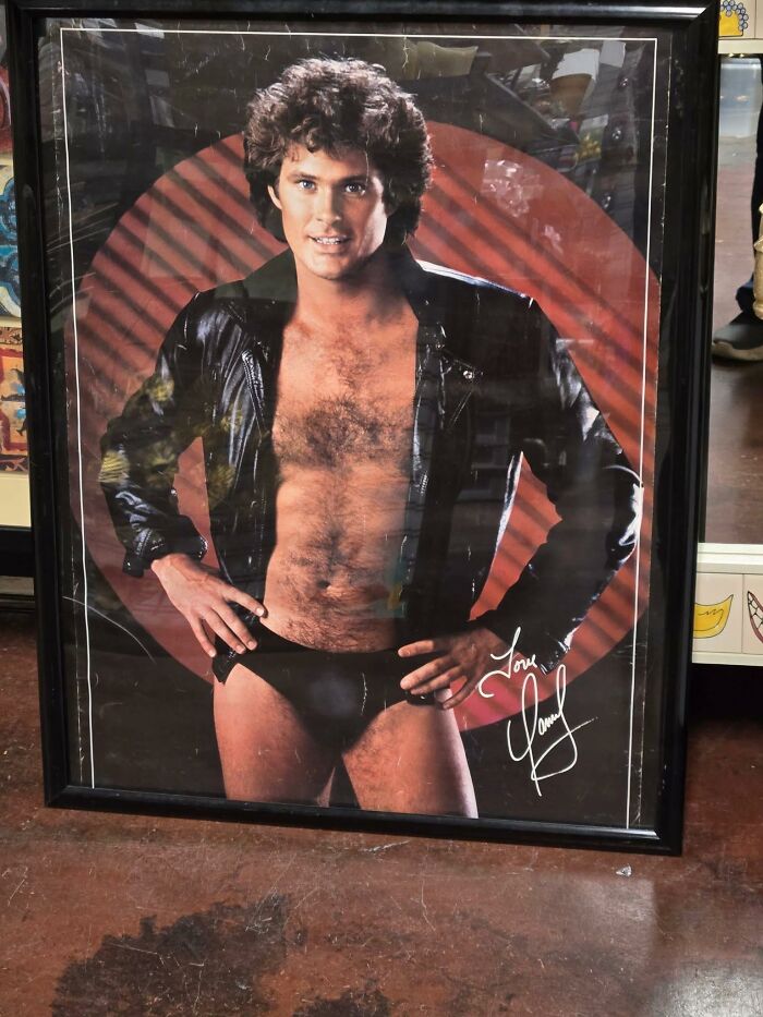 Framed vintage poster of a man in a leather outfit found at a secondhand shop.