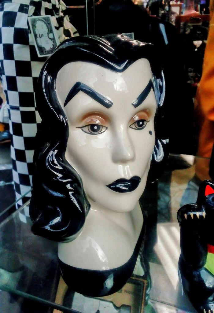 Ceramic head of a woman with dramatic eyebrows, found as a bizarre treasure in a secondhand shop display.