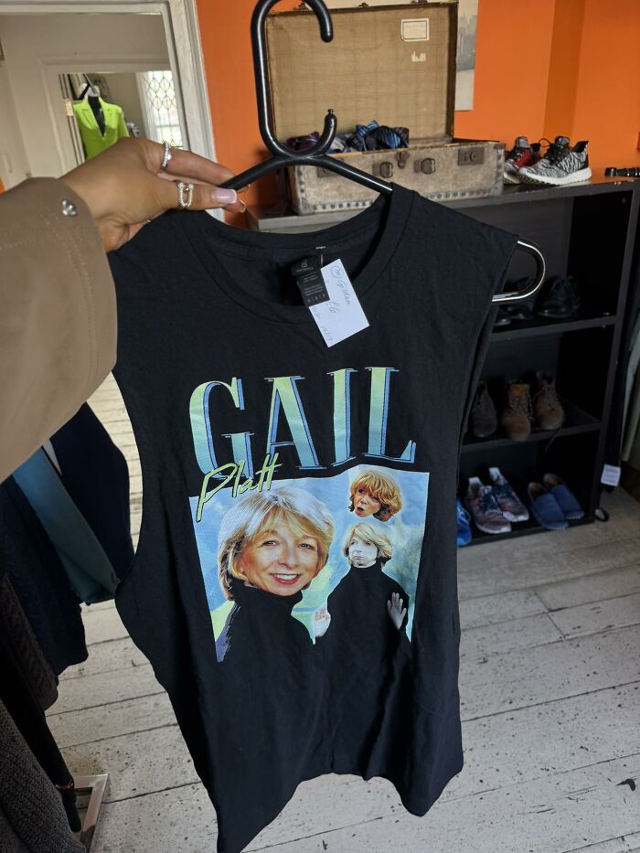 Sleeveless shirt with multiple images of a woman, found in a secondhand shop, hanging on a rack.